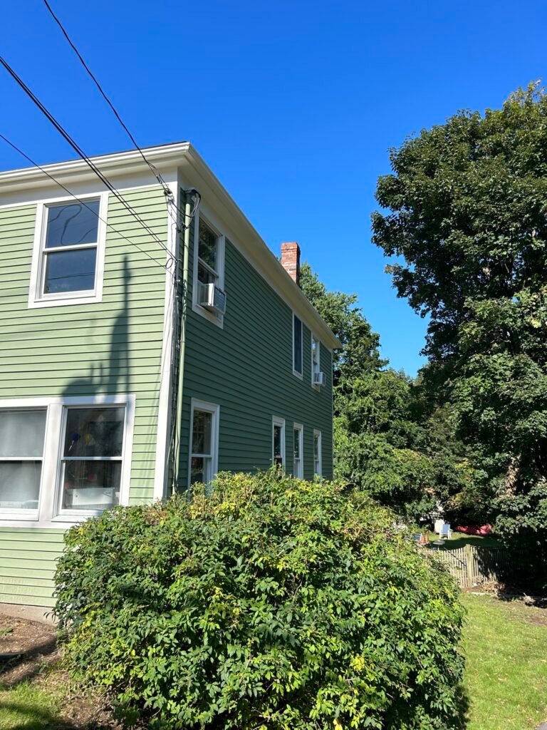 Green two-story house exterior in fall, Wakefield, MA area